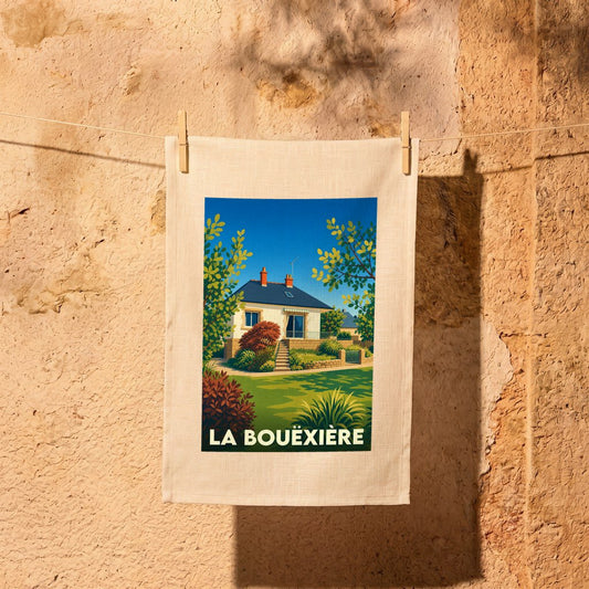 Torchon souvenir de la ville de La Bouëxière avec une illustration stylisée d'une maison et de son jardin.