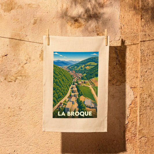 Torchon souvenir de la ville de La Broque avec une illustration stylisée d'un paysage de vallée verdoyant.