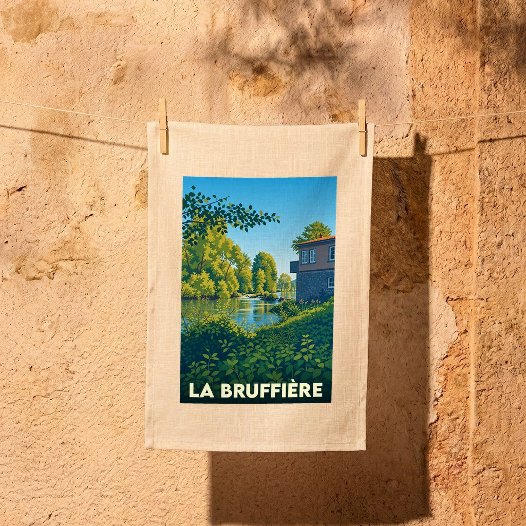 Torchon souvenir de la ville de La Bruffière avec une illustration stylisée d'un paysage de rivière.