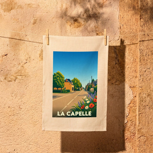 Torchon souvenir de la ville de La Capelle avec une illustration stylisée d'une rue ensoleillée et fleurie.