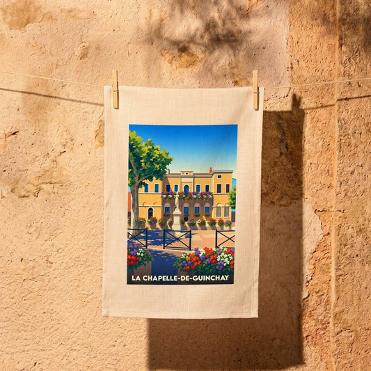 Torchon souvenir de la ville de La Chapelle-de-Guinchay avec une illustration colorée et stylisée de sa place principale.