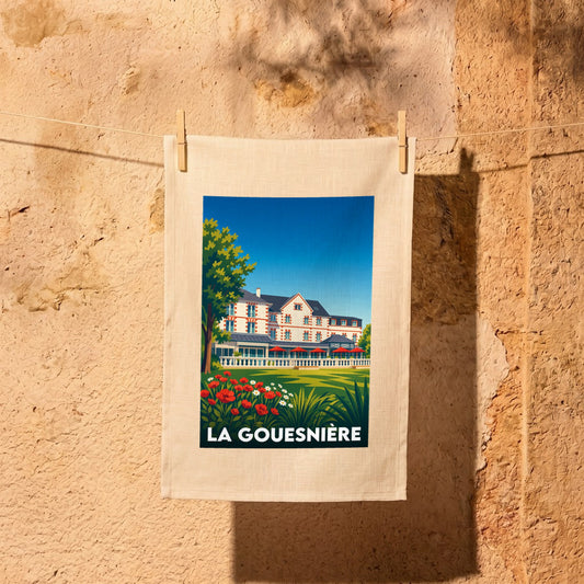 Torchon souvenir de la ville de La Gouesnière avec une illustration stylisée d'une grande demeure.
