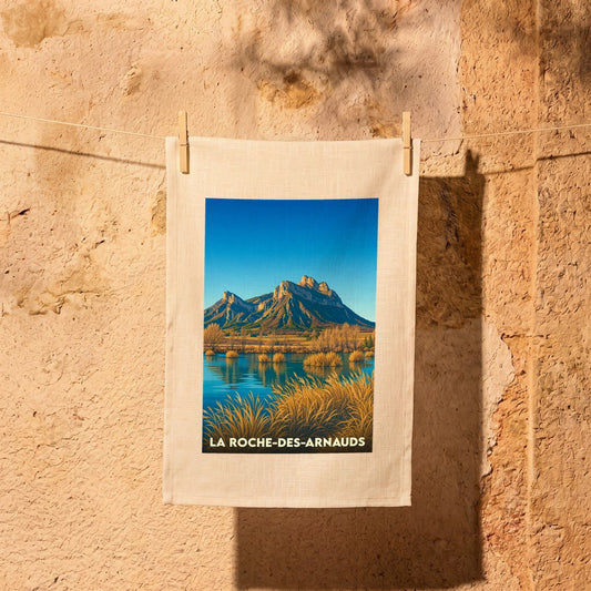 Torchon souvenir de la ville de La Roche-des-Arnauds avec une illustration stylisée d'un paysage de montagne.
