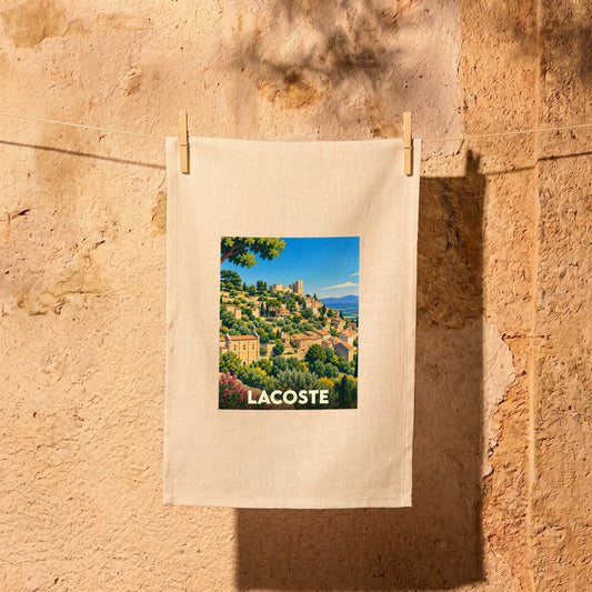Torchon souvenir de la ville de Lacoste avec une illustration stylisée de son village perché.