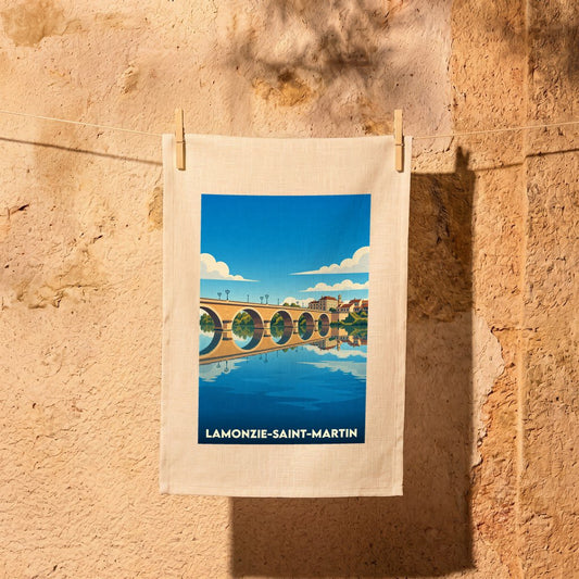 Torchon souvenir de Lamonzie-Saint-Martin arborant une illustration stylisée de son pont se reflétant dans l'eau.
