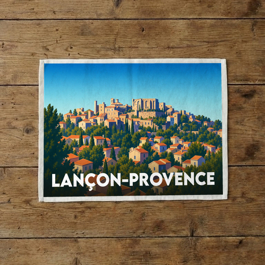 Torchon souvenir de la ville de Lançon-Provence avec une illustration stylisée d'un village perché.