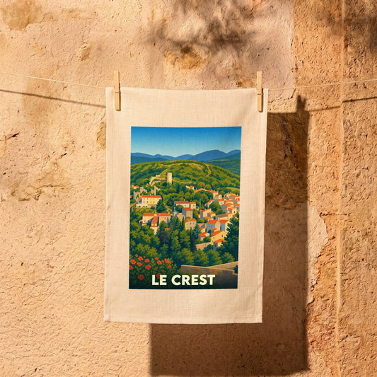 Torchon souvenir de la ville de Le Crest avec une illustration stylisée d'un paysage provençal.