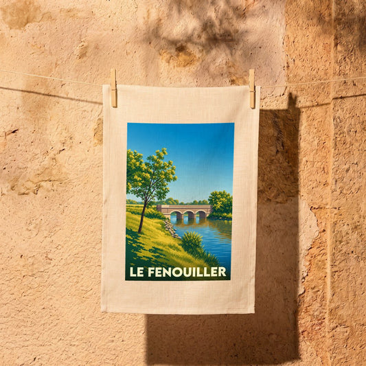 Torchon souvenir de la ville de Le Fenouiller avec une illustration stylisée représentant un pont sur une rivière.