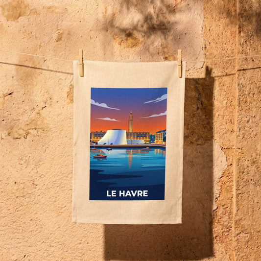 Torchon souvenir de la ville de Le Havre avec une illustration stylisée de son port au coucher du soleil.