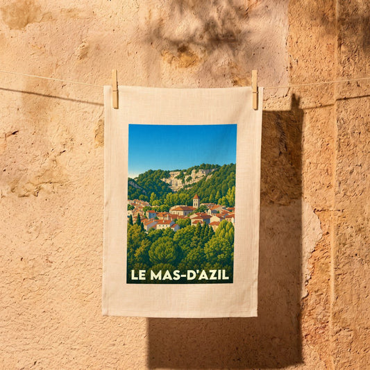 Torchon souvenir de la ville de Le Mas-d'Azil orné d'une illustration de style vintage représentant le village dans un paysage de falaises boisées.