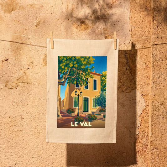 Torchon souvenir de la ville de Le Val illustré d'une scène de village provençal ensoleillé.