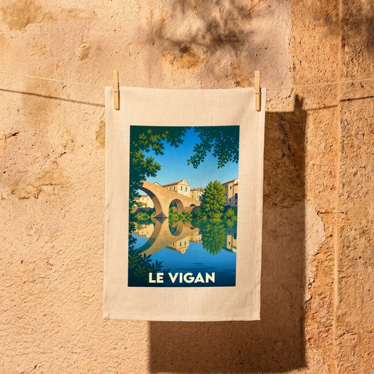 Torchon souvenir de la ville de Le Vigan avec une illustration stylisée d'un pont se reflétant dans l'eau.