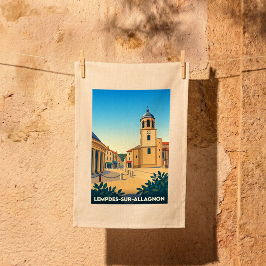 Torchon souvenir de la ville de Lempdes-sur-Allagnon avec une illustration stylisée de son église sous un ciel bleu.