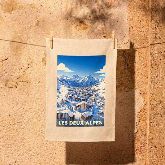 Torchon souvenir de la station Les Deux Alpes avec une illustration stylisée d'un village de montagne enneigé.