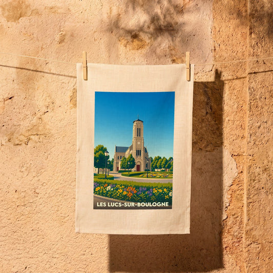 Torchon souvenir de la ville de Les Lucs-sur-Boulogne avec une illustration stylisée d'une église et d'un jardin fleuri.