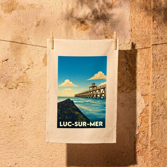 Torchon souvenir de la ville de Luc-sur-Mer avec une illustration stylisée de sa jetée en bois.