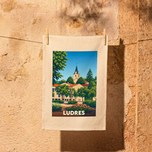Torchon souvenir de la ville de Ludres avec une illustration stylisée d'un clocher et de jardins fleuris.