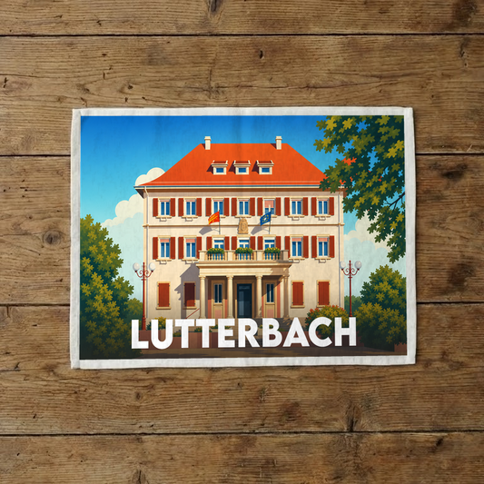 Torchon souvenir de la ville de Lutterbach illustré d'un bâtiment de style néoclassique sous un ciel bleu.
