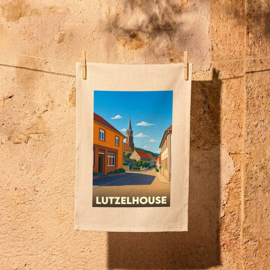 Torchon souvenir de la ville de Lutzelhouse avec une illustration stylisée d'une rue pittoresque.