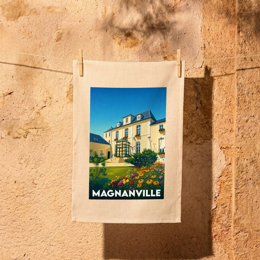 Torchon souvenir de la ville de Magnanville illustré par une grande maison bourgeoise et son jardin fleuri.