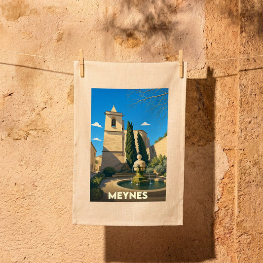 Torchon souvenir de la ville de Meynes avec une illustration stylisée d'une place provençale.