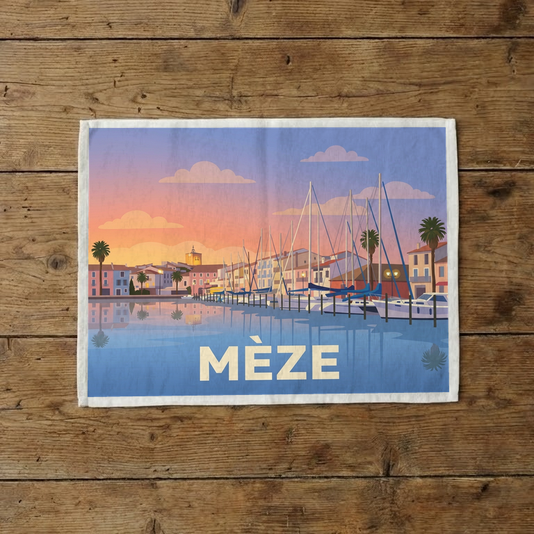 Torchon souvenir de la ville de Mèze avec une illustration stylisée du port au coucher du soleil.