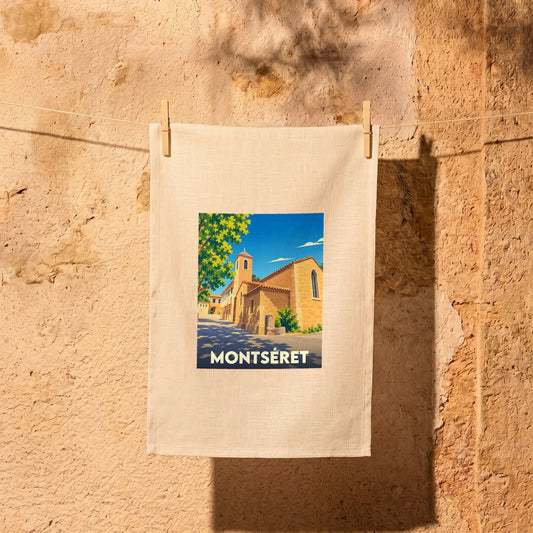 Torchon souvenir de la ville de Montséret illustré d'un paysage urbain stylisé et ensoleillé.