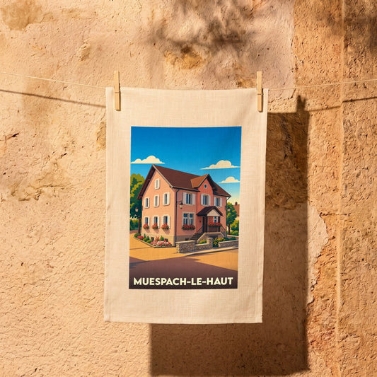 Torchon souvenir de la ville de Muespach-le-Haut illustré d'une maison alsacienne stylisée.