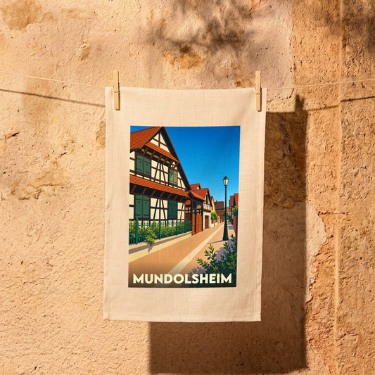 Torchon souvenir de la ville de Mundolsheim avec une illustration stylisée de maisons à colombages alsaciennes.