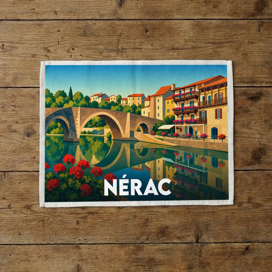 Torchon souvenir de la ville de Nérac orné d'une illustration stylisée représentant son pont vieux et ses maisons à colombages au bord de l'eau.
