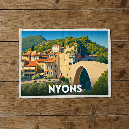 Torchon souvenir de la ville de Nyons avec une illustration stylisée de son pont et de ses maisons provençales.