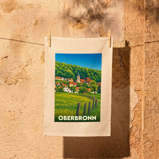 Torchon souvenir de la ville d'Oberbronn avec une illustration stylisée de son paysage vallonné.