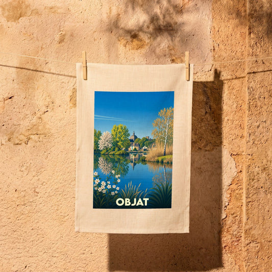 Torchon souvenir de la ville d'Objat avec une illustration stylisée d'un paysage lacustre.