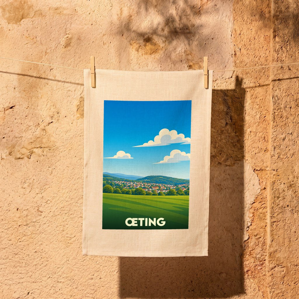 Torchon souvenir de la ville de Œting avec une illustration stylisée d'un paysage champêtre.