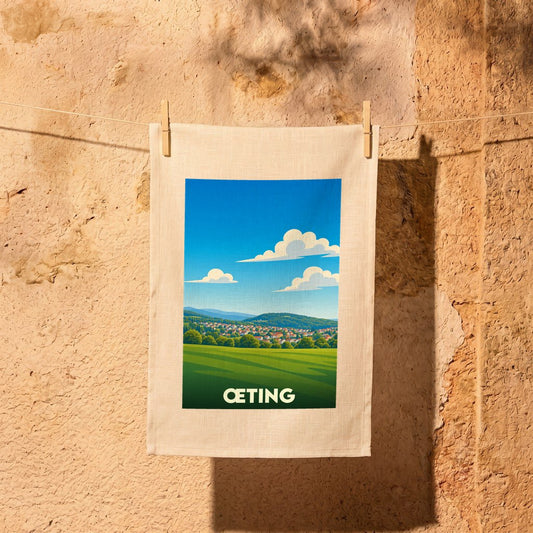 Torchon souvenir de la ville de Œting avec une illustration stylisée d'un paysage champêtre.