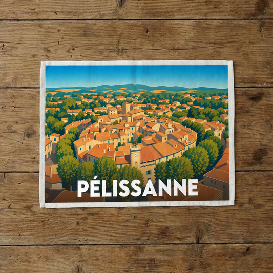 Torchon souvenir de la ville de Pélissanne avec une illustration stylisée d'un village provençal.