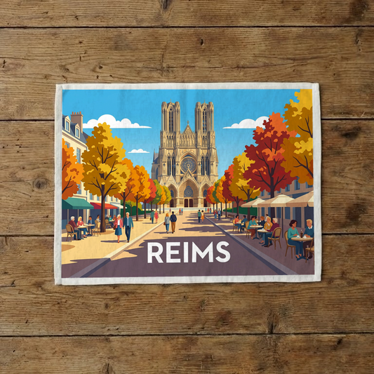 Torchon souvenir de la ville de Reims avec une illustration stylisée de sa cathédrale et d'une rue animée en automne.