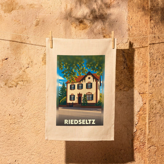 Torchon souvenir de la ville de Riedseltz avec une illustration stylisée d'une maison traditionnelle.
