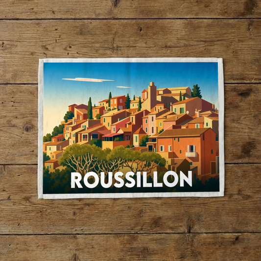 Torchon souvenir de la ville de Roussillon avec une illustration stylisée et colorée de ses maisons ocres.