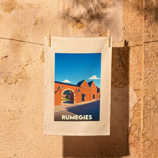 Torchon souvenir de la ville de Rumegies illustré d'un dessin stylisé de bâtiments locaux.