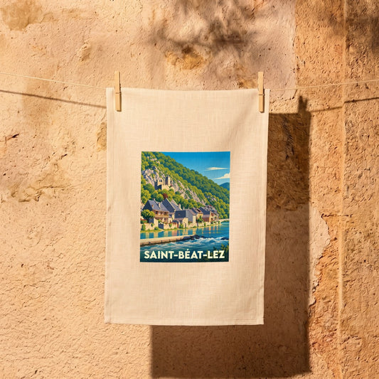 Torchon souvenir de la ville de Saint-Béat-Lez avec une illustration stylisée d'un paysage montagneux en bord de rivière.