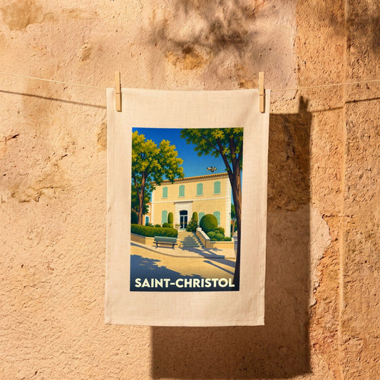 Torchon souvenir de la ville de Saint-Christol avec une illustration stylisée d'une bâtisse provençale.