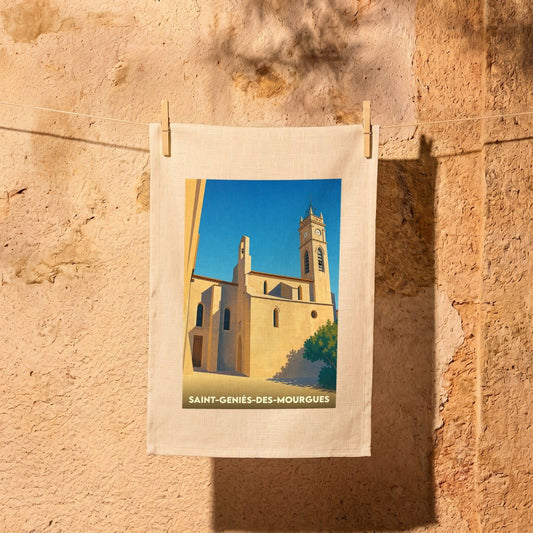 Torchon souvenir de la ville de Saint-Geniès-des-Mourgues avec une illustration stylisée de son église sous un ciel bleu.