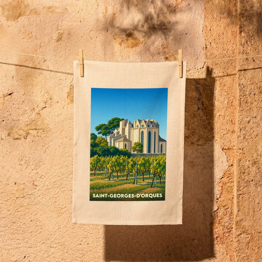 Torchon souvenir de Saint-Georges-d'Orques illustré d'un vignoble et d'une église sous un ciel bleu.