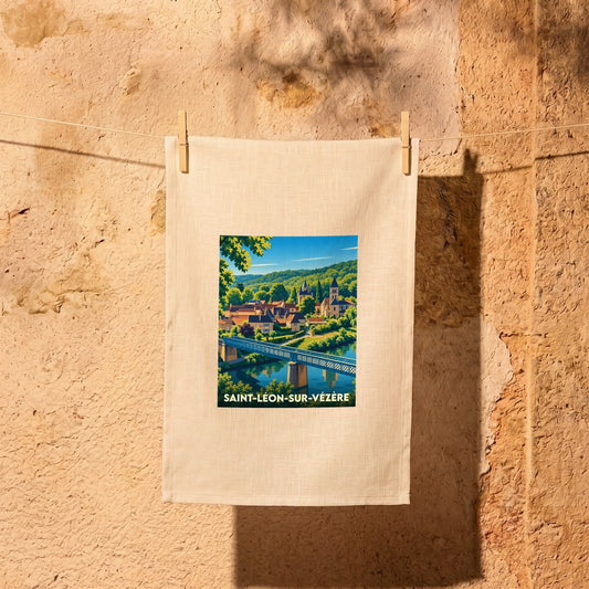 Torchon souvenir de la ville de Saint-Léon-sur-Vézère avec une illustration colorée et stylisée de son pont et de son église.