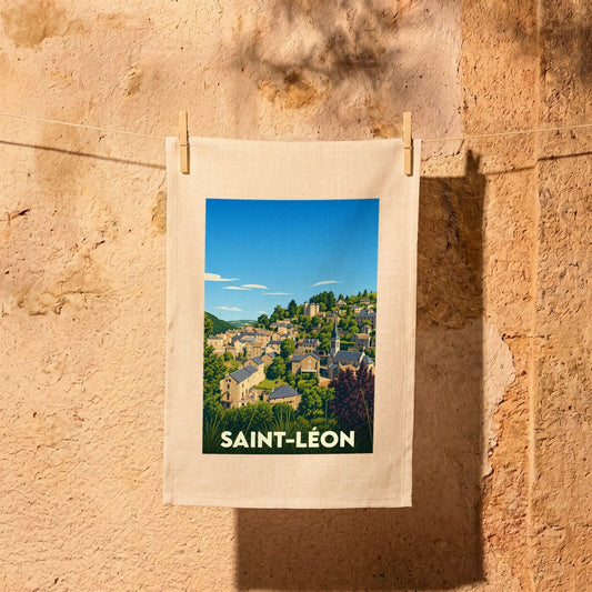 Torchon souvenir de la ville de Saint-Léon avec une illustration stylisée d'un village de campagne.