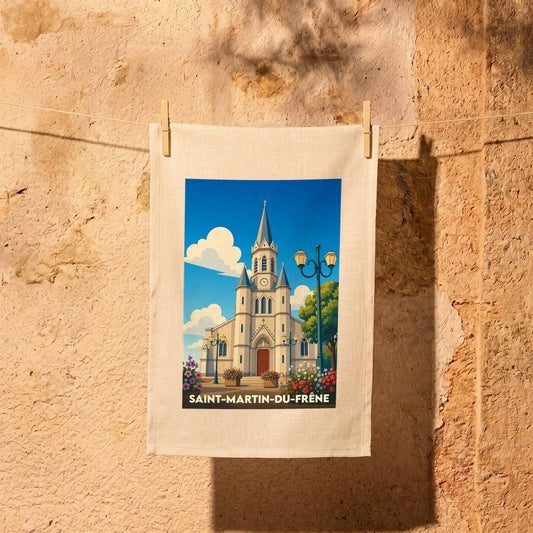 Torchon souvenir de la ville de Saint-Martin-du-Frêne avec une illustration stylisée de son église sous un ciel bleu.