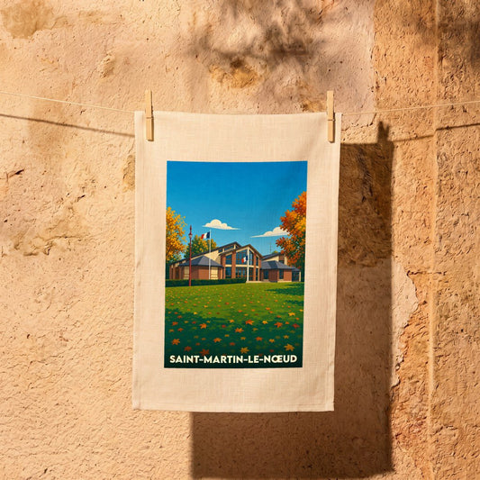 Torchon souvenir de la ville de Saint-Martin-le-Nœud avec une illustration stylisée d'un bâtiment sous un ciel bleu d'automne.
