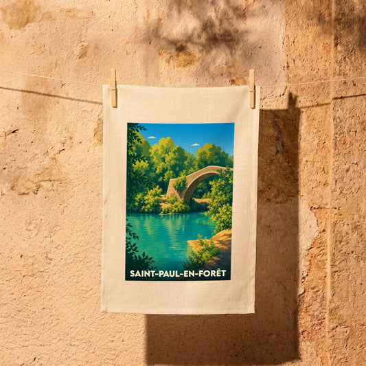 Torchon souvenir de la ville de Saint-Paul-en-Forêt illustré d'un pont en pierre dans un paysage forestier.