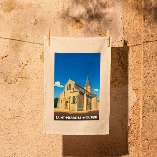 Torchon souvenir de la ville de Saint-Pierre-le-Moûtier avec une illustration stylisée de son église.